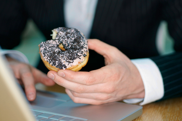 Buy YouTube subscribers - man eating donut at computer