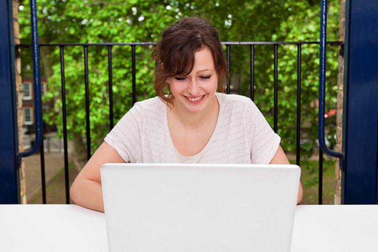Make money on YouTube — happy woman using laptop